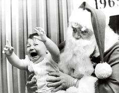 an old photo of santa claus holding a baby