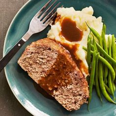 meatloaf, mashed potatoes and green beans on a plate with a fork