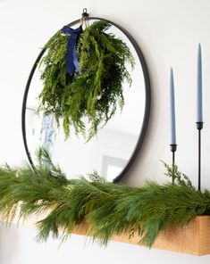 Mantel garland and large round black mirror by Plank & Pine Interior Design Wreath Mirror Decor, Indoor Wreaths On Windows, Wreath On Round Mirror, Garland On Mirror Christmas, Round Mirror Christmas Decor, Mirror With Wreath, Wreath Over Mirror, Oval Mirror Decor, Wreath On Mirror