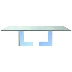 a rectangular glass table with metal legs and blue tiles on the top, against a white background