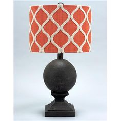 an orange and white lampshade on a black base with a red lamp shade