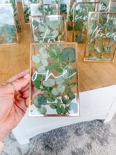 a person holding up some cards with leaves on them and the word love spelled in cursive writing