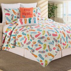 a bed with a colorful comforter and pillows