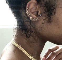 a close up of a person with ear piercings and a measuring tape around their neck