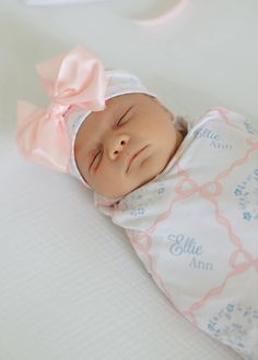 a baby is sleeping with a pink bow on it's head and she has her eyes closed