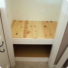 a wooden bench sitting in the corner of a room next to an open closet door