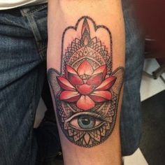 a hamsa tattoo with an eye and flower on it