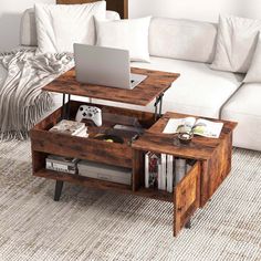 a coffee table with a laptop on it in the middle of a living room filled with furniture