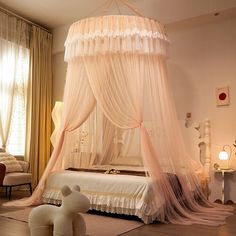 a bedroom with a canopy bed and two teddy bears sitting on the floor next to it