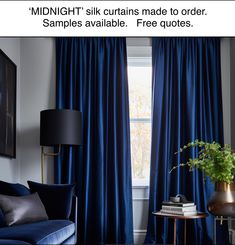 a living room with blue drapes and a couch in front of a window that reads midnight