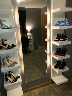 a closet filled with lots of shoes next to a wall mounted light up shoe rack