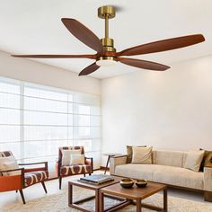 a living room with a couch, coffee table and ceiling fan in the middle of it