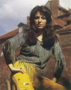 a woman with long hair sitting on top of a yellow object