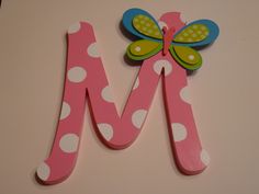 the letter m is decorated with polka dots and a butterfly