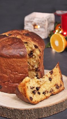 a loaf of cake sitting on top of a wooden plate next to a piece of bread