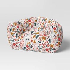 a flowery chair with white and red flowers on the front, sitting against a gray background