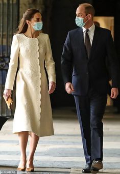 a man and woman wearing masks walking down the street