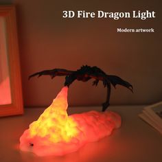 a dragon lamp sitting on top of a table next to a framed photo and a mirror