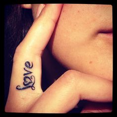 a woman's wrist tattoo with the word love on it