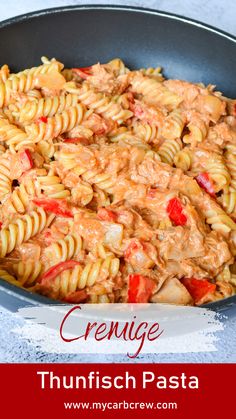 a skillet filled with pasta and sauce on top of a white counter next to a red sign that says cremice