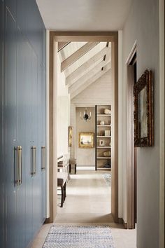 a hallway leading to a bedroom with blue closets and white carpeted flooring