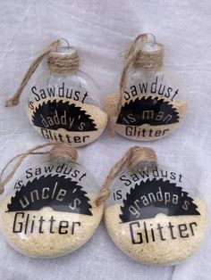 four glass bottle ornaments with labels on them