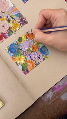 the person is drawing on paper with colored pencils and watercolors in front of them