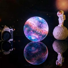 an image of a space scene with a camera and a ball on the ground next to it