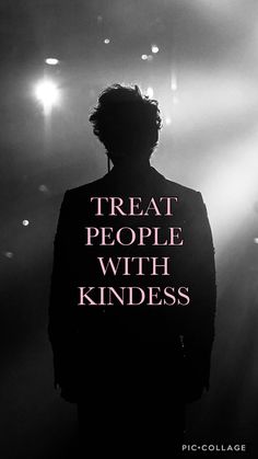 a man standing in front of spotlights with the words treat people with kindness