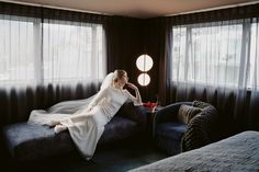 a woman sitting on top of a bed in a bedroom