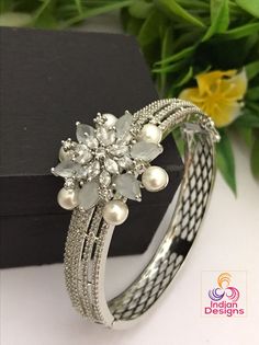 Wear this stunning bracelet as an everyday essential! This delicate and feminine bangle bracelet features a sparkling silver finish, studded with colorful stones. The beautiful handcrafted design will be sure to make any outfit stand out. Rhodium Plated silver tone clasp openable bangle bracelet in floral design studded with pearls. The size of these bangle bracelet is fit for 2.6 to 2.8 as it is an openable kada bangle. Diamond Kada, Stone Bangles, Bangles Silver, Colorful Stones, Stone Bangle, Kundan Necklaces, Cz Jewelry, American Diamond, Multi Stone