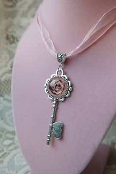 "Decoupage paper image (rose) in this heart key pendant. The pendant hangs on a pink gossamer ribbon that is 17\" long with a 2\" extension. The key is made of a strong, silver plated, metal alloy. Cabochon is glass and measures 20 mm in diameter around the rose." Image Rose, Brown Aesthetics, Paper Image, Key Pendant Necklace, Heart Key, Heart And Key, Key Necklace, Pretty Clothes, Key Pendant