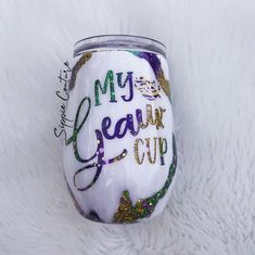 a wine glass with the words my dear cup painted on it sitting on a white furnishing