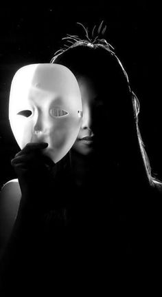 a woman holding a mask in front of her face