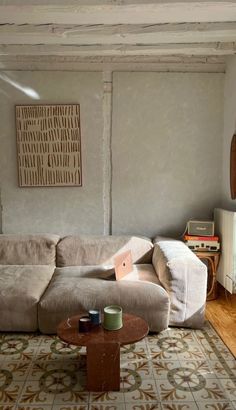 a living room with a couch, coffee table and rug on the floor in front of it