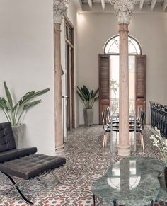 a living room filled with furniture and a large window covered in shuttered glass doors