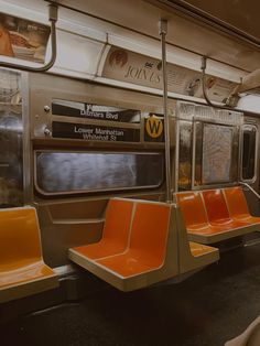 an empty subway car with orange seats