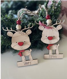 two wooden reindeer ornament hanging from a christmas tree