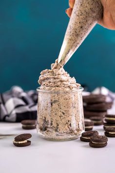 a person is dipping cookies into a jar