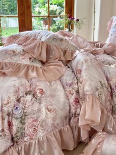 the comforter is made up with ruffled edges and pink flowers on it's bed