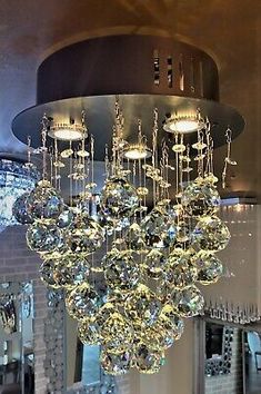 a chandelier hanging from the ceiling in a room filled with mirrors and lights