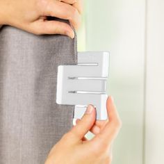 a person is holding onto the back of a gray chair with two white handles and one hand on it