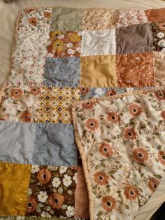 a quilt is laying on top of a bed with many different colors and patterns in it