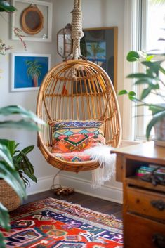 a hanging chair in the corner of a room with plants and pictures on the wall