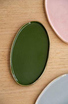 three plates sitting on top of a wooden table with one empty plate in the middle