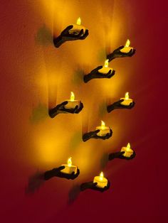 several lit candles are placed on the wall