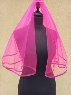 a mannequin with a pink veil on top of it