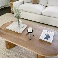 a living room with white couches and a coffee table in front of the couch