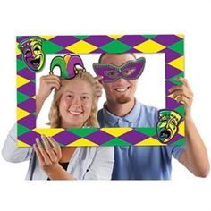 a man and woman wearing mardi gras masks in front of a photo frame