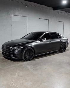 a black mercedes s - class parked in a garage